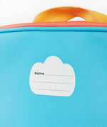 A close up of the Frugi kids pack a lunch bag in rainbow sun. Showing the name tag patch detail and yellow carry handle detail 