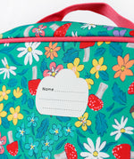 A close up of the Frugi kids pack a lunch bag in wild woods. Showing the name tag patch detail and pink trim 