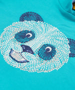 A close up of the Frugi kids oversized blue panda hoodie. Showing the white and navy panda embroidery on the front on blue organic cotton fabric