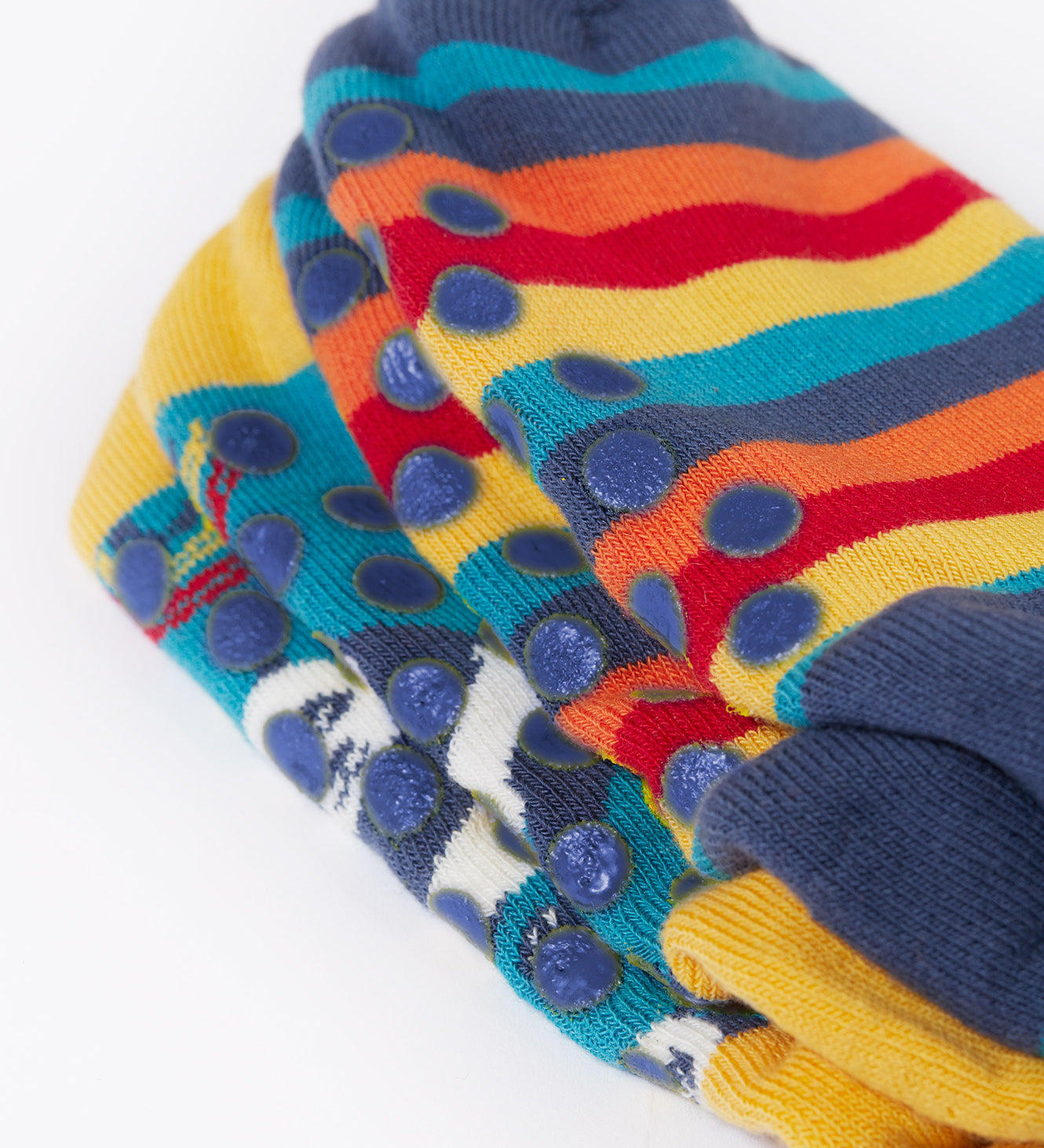 A close up of the navy grippy circles on the soles of the Frugi Panda Play Great Organic Cotton Grippy Socks for Kids. A 2 pack of socks one with a repeat panda print and one pair has a rainbow stripe design with a single panda. These socks are part of a wide range of organic cotton clothing for children available here at Babipur. 