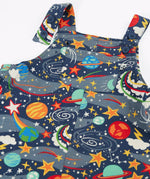 Close up of the button up straps and chest pocket on the front of the Frugi parsnip organic cotton dungaree in navy with an all over explore the stars print.