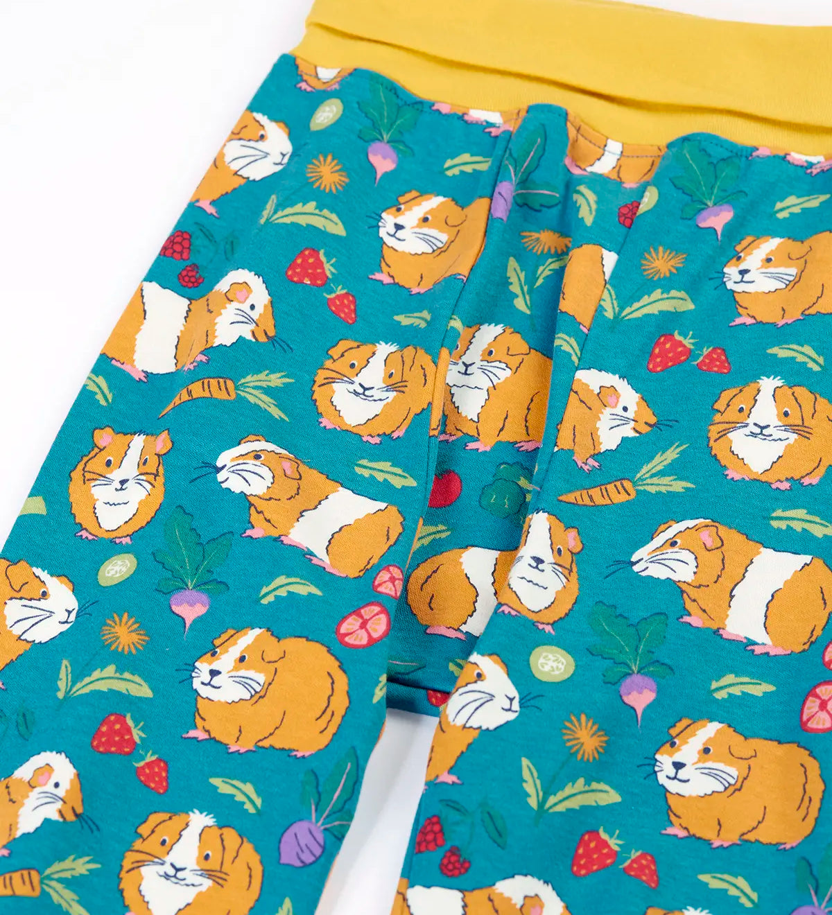 Frugi GOTS organic cotton parsnip pants in teal with a repeating guinea pig print and a yellow elasticated waistband for extender wear