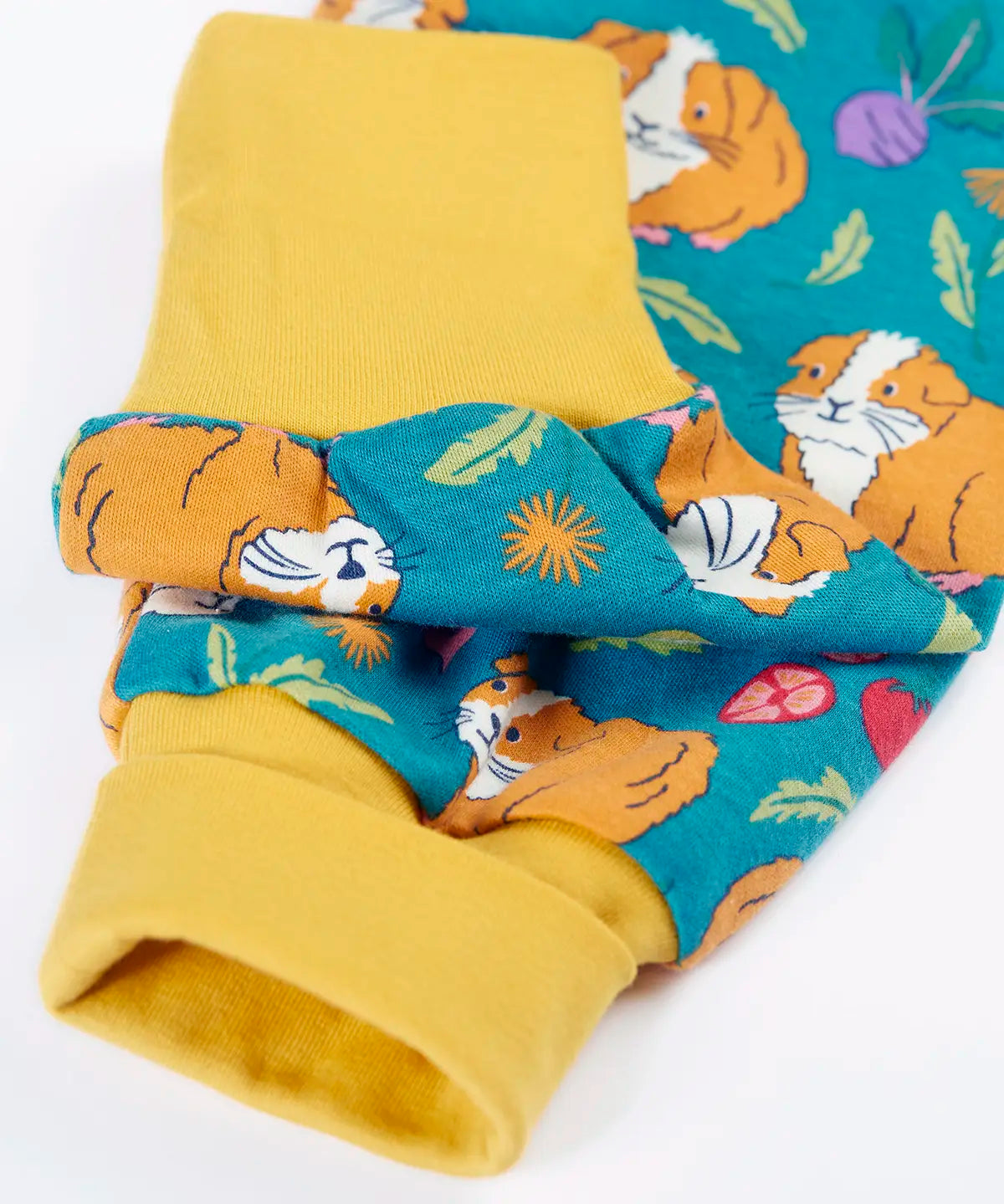 Frugi GOTS organic cotton parsnip pants in teal with a repeating guinea pig print showing a close up of the yellow fold up cuffs for extender wear
