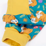 Frugi GOTS organic cotton parsnip pants in teal with a repeating guinea pig print showing a close up of the yellow fold up cuffs for extender wear