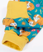 Frugi GOTS organic cotton parsnip pants in teal with a repeating guinea pig print showing a close up of the yellow fold up cuffs for extender wear