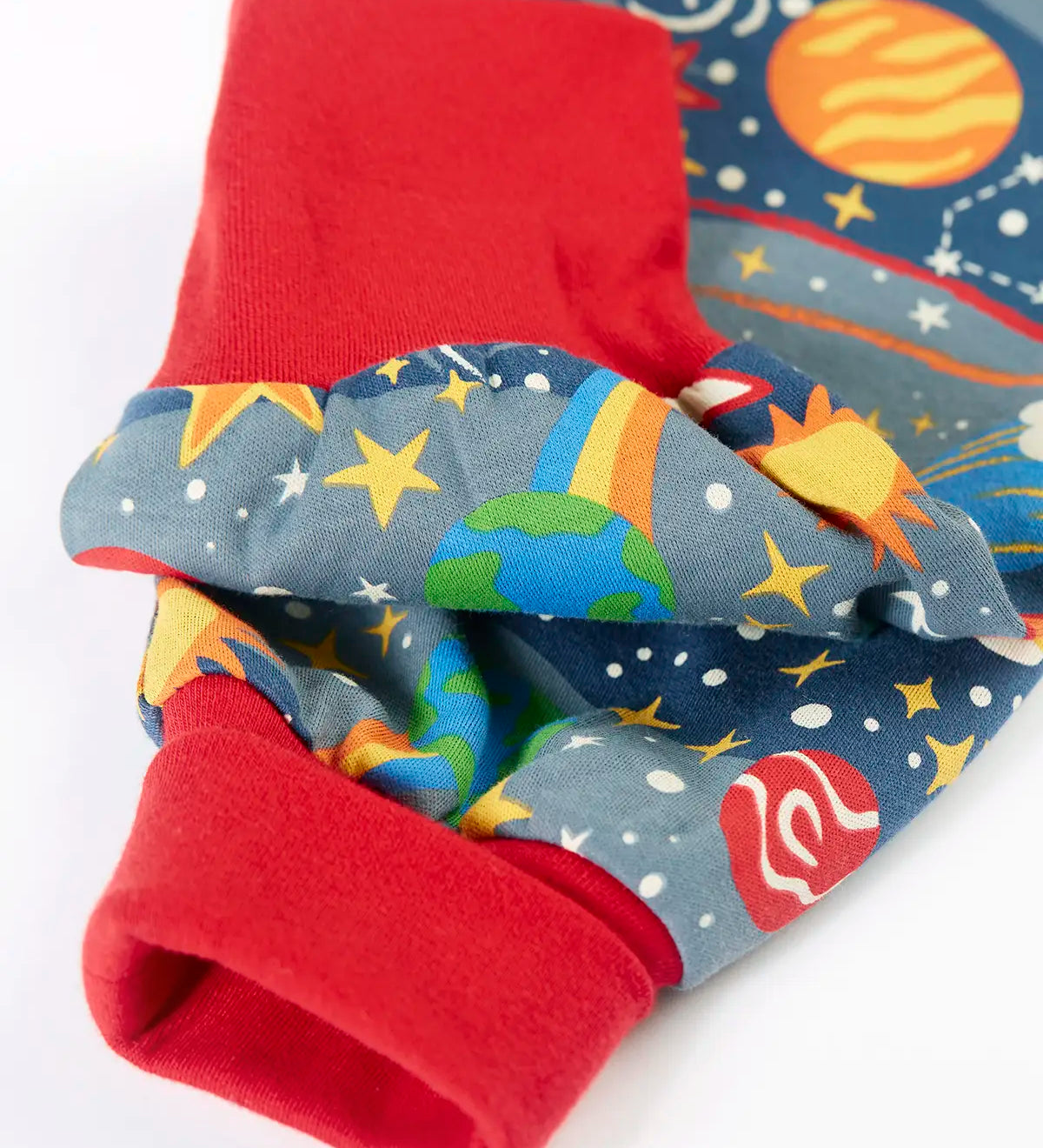Frugi GOTS organic cotton parsnip pants in navy with outer space themed prints showing a close up of the red fold up cuffs for extender wear