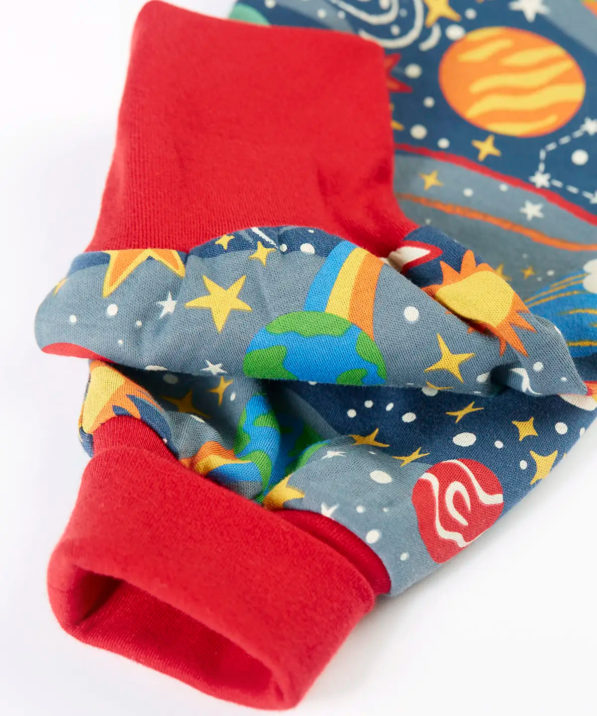 Frugi GOTS organic cotton parsnip pants in navy with outer space themed prints showing a close up of the red fold up cuffs for extender wear