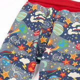 Frugi GOTS organic cotton parsnip pants in navy with outer space themed prints with a red fold up waist band for extender wear