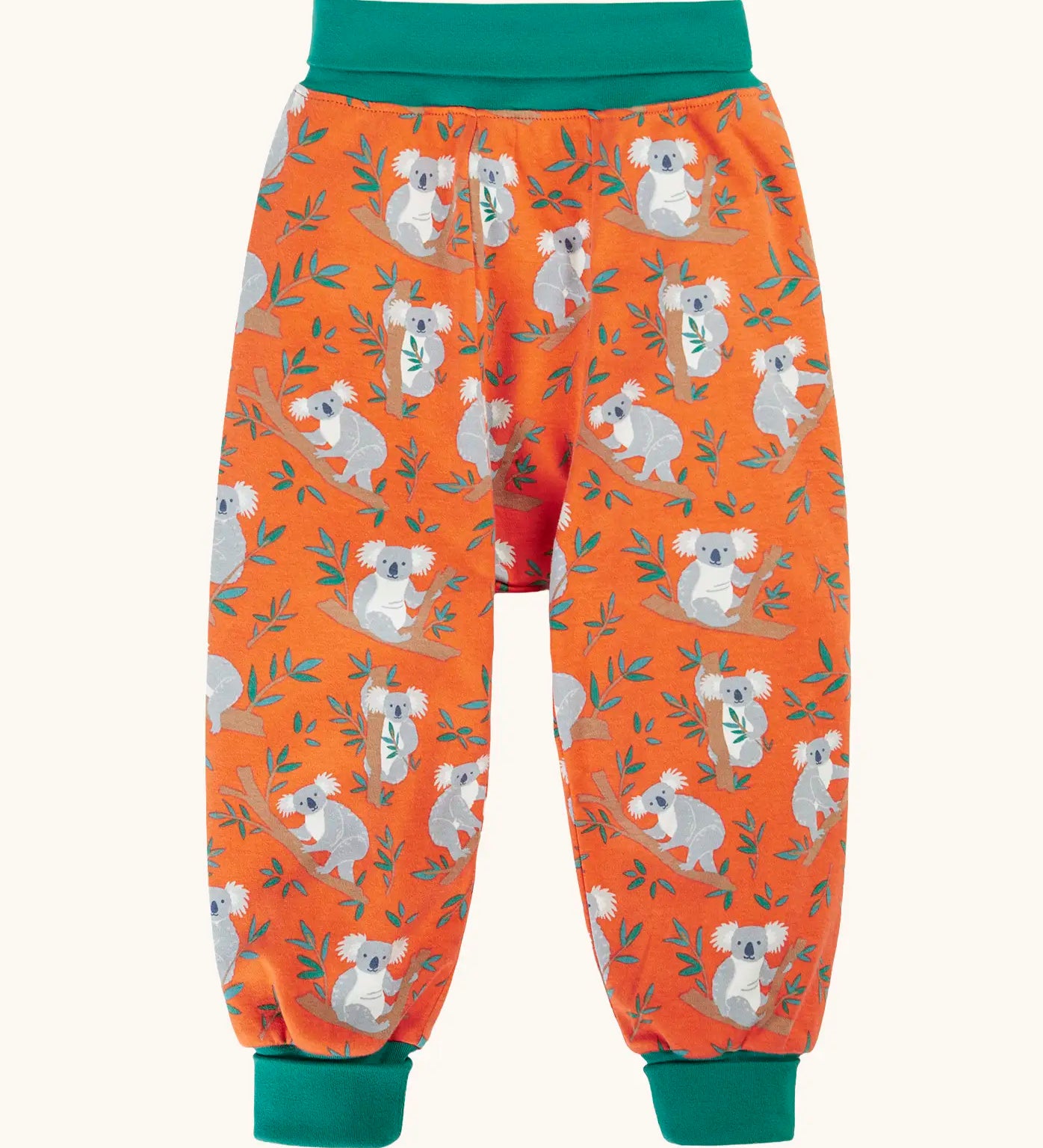 Frugi parsnip pants in salamander orange with an all over koala cuddles print and green waist and leg cuffs.