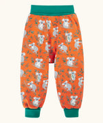 Frugi parsnip pants in salamander orange with an all over koala cuddles print and green waist and leg cuffs.
