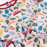 A close up of the Frugi kids pelican fun-guys amelia dress showing the playful woodland inspired print detail on pink organic cotton fabric.