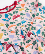 A close up of the Frugi kids pelican fun-guys amelia dress showing the playful woodland inspired print detail on pink organic cotton fabric.