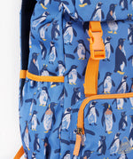 A close up of the Frugi kids trail blazing backpack in penguin waddle. Showing orange buckle for the flip top  and bottle holder detail