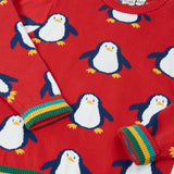 Close up of the Frugi scarlet penguins organic cotton jolly knitted jumper showing the rainbow stripe hemline and arm cuffs.