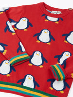 Close up of the Frugi scarlet penguins organic cotton jolly knitted jumper showing the rainbow stripe hemline and arm cuffs.