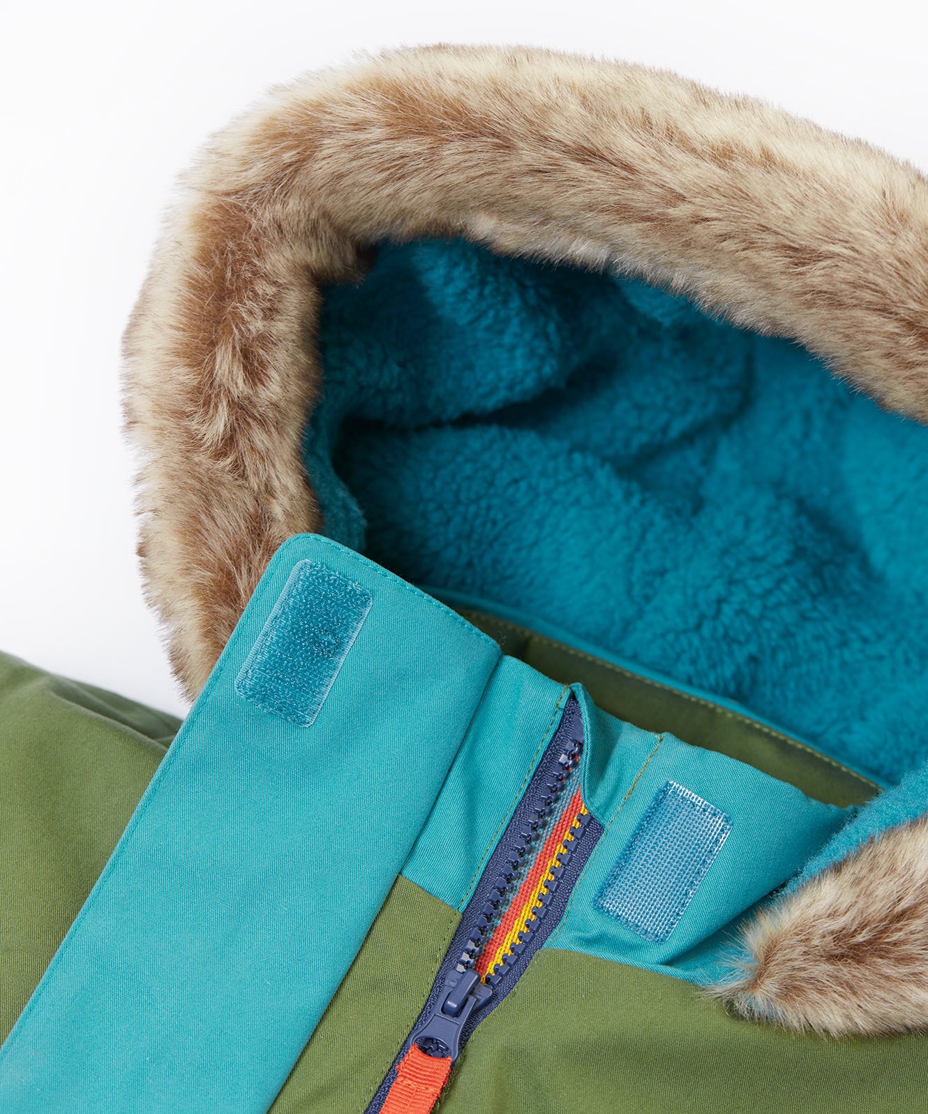 A close up of the Frugi khaki penhale colourblock parka showing the soft furry hood with blue fleece inner liner and velcro fastener for a secure fit. Features a full length zip.
