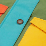 A close up of the Frugi khaki penhale colourblock parka showing the button fastener and pocket detail on organic cotton fabric