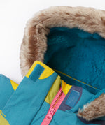 A close up of the Frugi super spot penhale parka showing the soft furry hood with blue fleece inner liner and velcro fastener for a secure fit. Features a full length zip in pink trim.