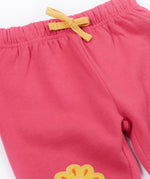 A close up of the yellow coloured waist tie on the Frugi rose pink coloured flower and mushroom crawlers kids joggers.