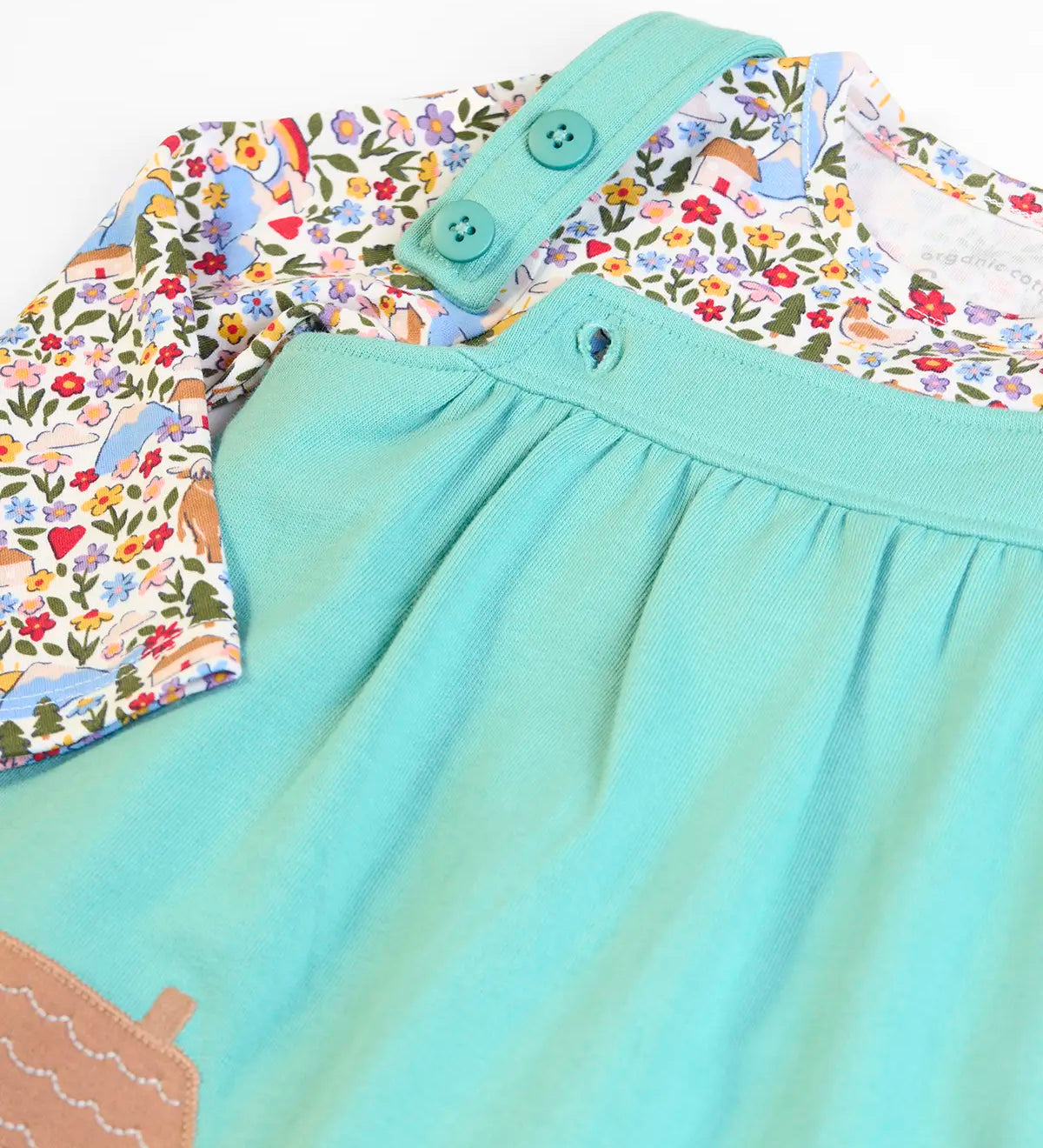Frugi GOTS 100% organic cotton pinafore dress outfit showing the adjustable shoulder straps and a floral top underneath