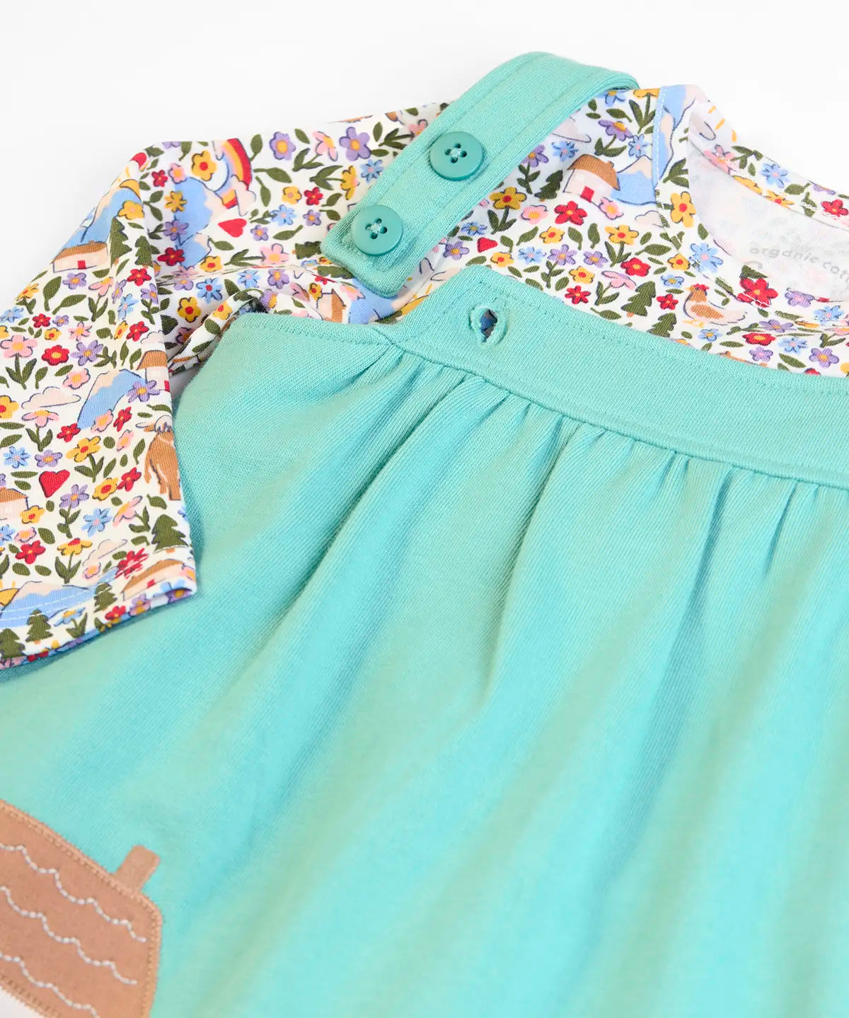 Frugi GOTS 100% organic cotton pinafore dress outfit showing the adjustable shoulder straps and a floral top underneath