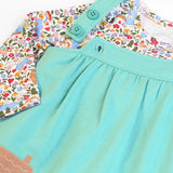 Frugi GOTS 100% organic cotton pinafore dress outfit showing the adjustable shoulder straps and a floral top underneath