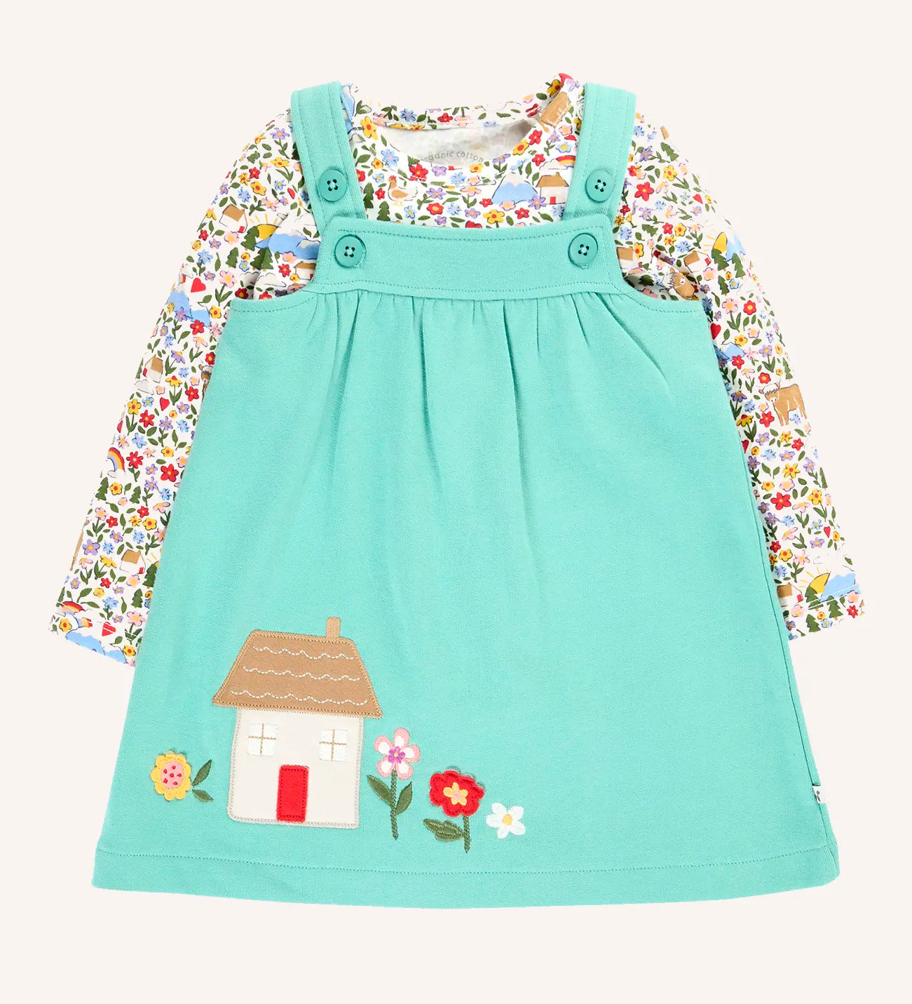 Frugi Pippa light moss green pinafore dress outfit with highland fields print long sleeved body. The light green dress has a highland house and floral applique detail on the front