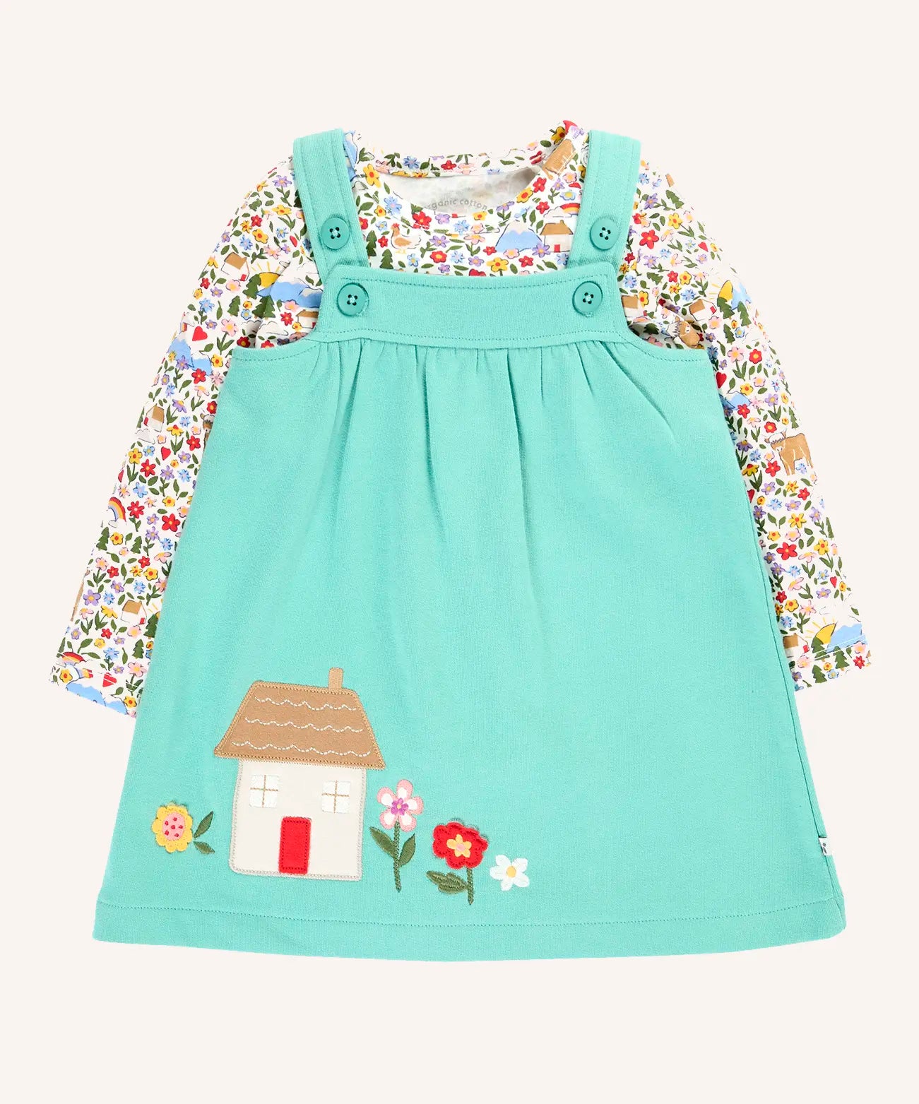 Frugi Pippa light moss green pinafore dress outfit with highland fields print long sleeved body. The light green dress has a highland house and floral applique detail on the front