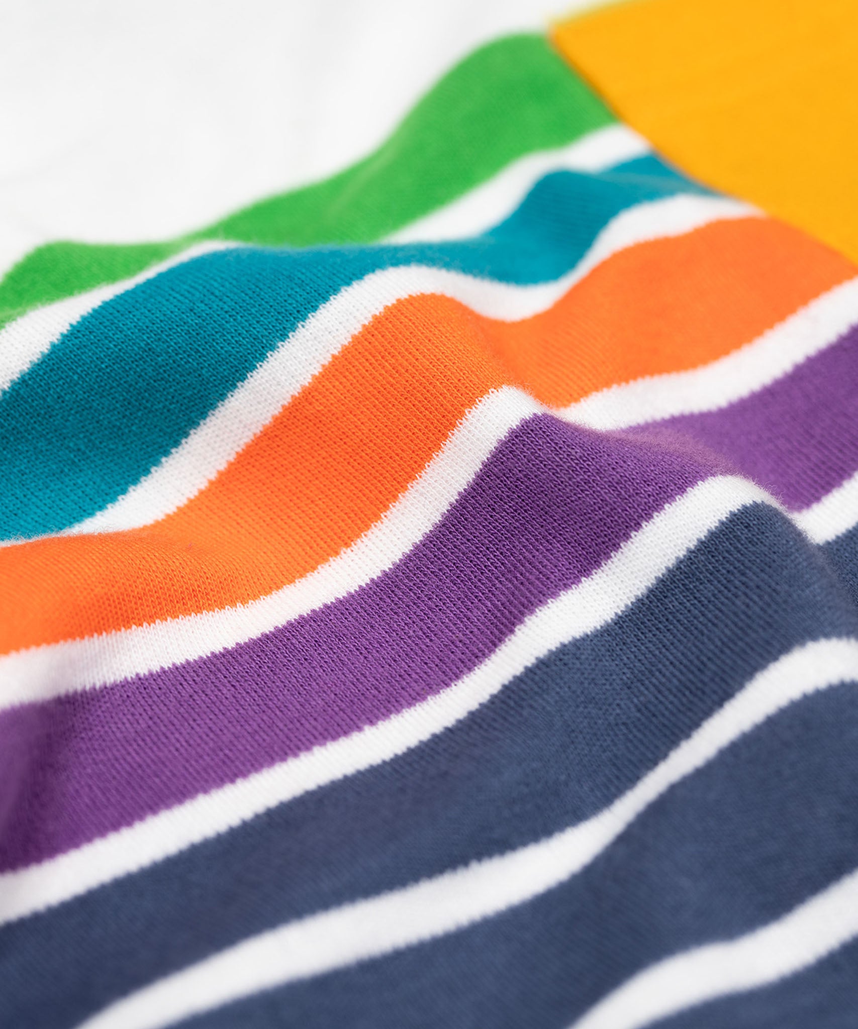 A super close up shot of the material of the The Frugi Piran pocket navy striped organic cotton child's long sleeved top. The material appears nice and smooth.