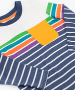 A close up of the Frugi Piran pocket navy striped organic cotton child's long sleeved top. The top has a navy and white stripes at the bottom, then 4 coloured stripes and a white band at the top with a small yellow gold coloured pocket on the chest