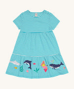 Frugi Pixy Sea Moss Mini Stripe Dress laid flat, with a Sealife print along the bottom, featuring whales, dolphins, sharks, a Mermaid and some small fish, surrounded by colorful seaweed.