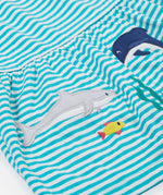 A close up of Frugi Pixy Sea Moss Mini Stripe Dress, with a Sealife print along the bottom, featuring a shark, a dolphin and a small fish.