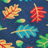 Frugi children's playtime waterproof coat with a multi-coloured acorn tumble print on a navy background, close up of water droplets formed on the material.