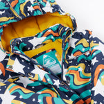 A close up of the Frugi kids playtime coat in magic stars. Showing the zip and name tag detail on the outer space inspired print. 