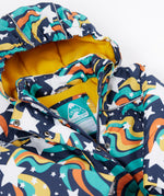 A close up of the Frugi kids playtime coat in magic stars. Showing the zip and name tag detail on the outer space inspired print. 