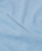 Close up of the organic cotton material of the Frugi pointelle long sleeved baby body in winter sky blue. 