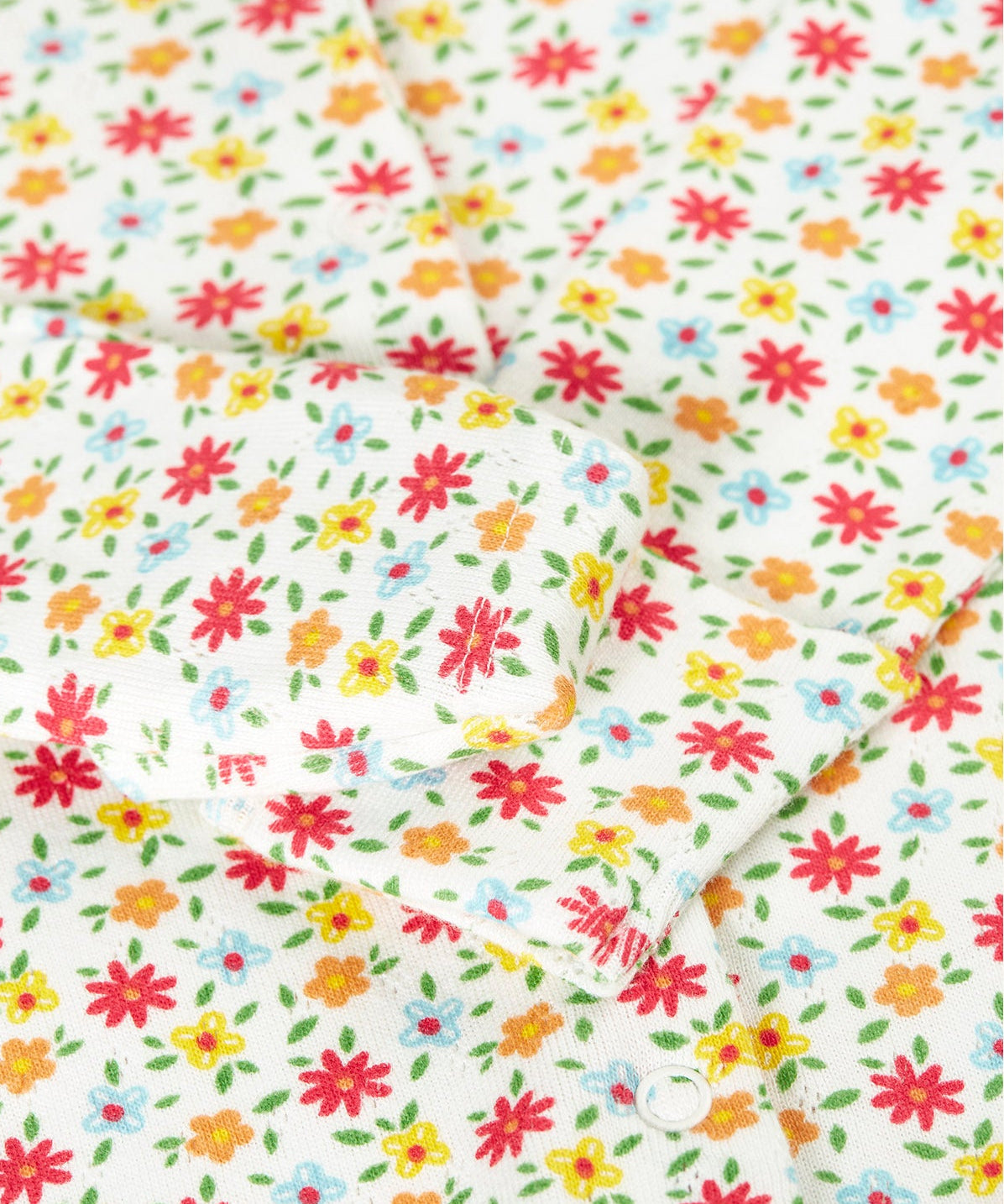 A close up of the fold over mitts on the Frugi Pointelle Organic Cotton footed Babygrow with an all over Ditsy Floral print.