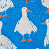 A close up of a white goose on the material of the Frugi cobalt blue coloured rain jacket, rain drops can be seen pooling on the jacket. 