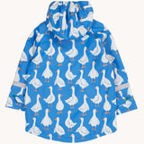 The back of a Frugi cobalt blue coloured rain jacket with white all over goose print. The jacket has reflective strips around the arms.