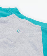Close up of the Frugi kids koala raglan t-shirt. Showing the popper fasteners on the back for easy fitting on grey and blue organic cotton fabric