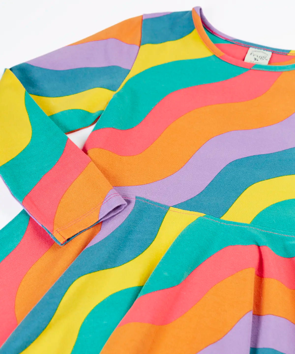 Close up of the Frugi GOTS organic cotton long sleeved sofia skater dress with a rainbow ric rac pattern.