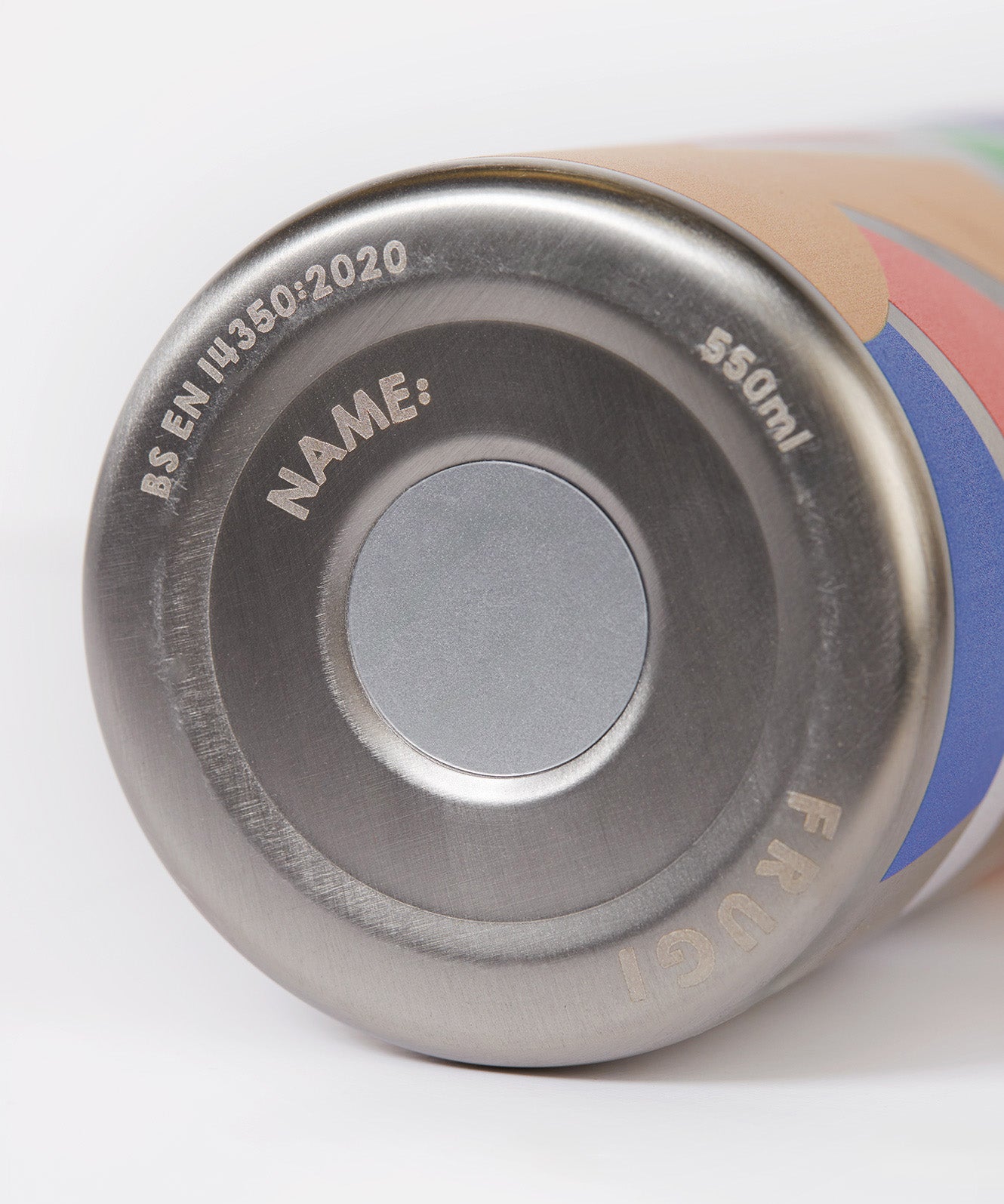 A close up of the Frugi kids Insulated bottle in rainbow sun. Showing the underneath the stainless steel bottle where a name can be written on 