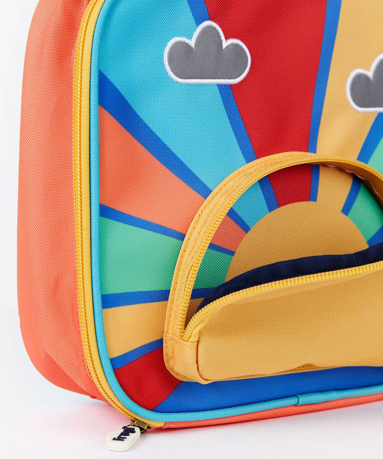 A close up of the Frugi kids pack a lunch bag in rainbow sun. Showing the yellow zip trim and opened front compartment revealing the rising sun.