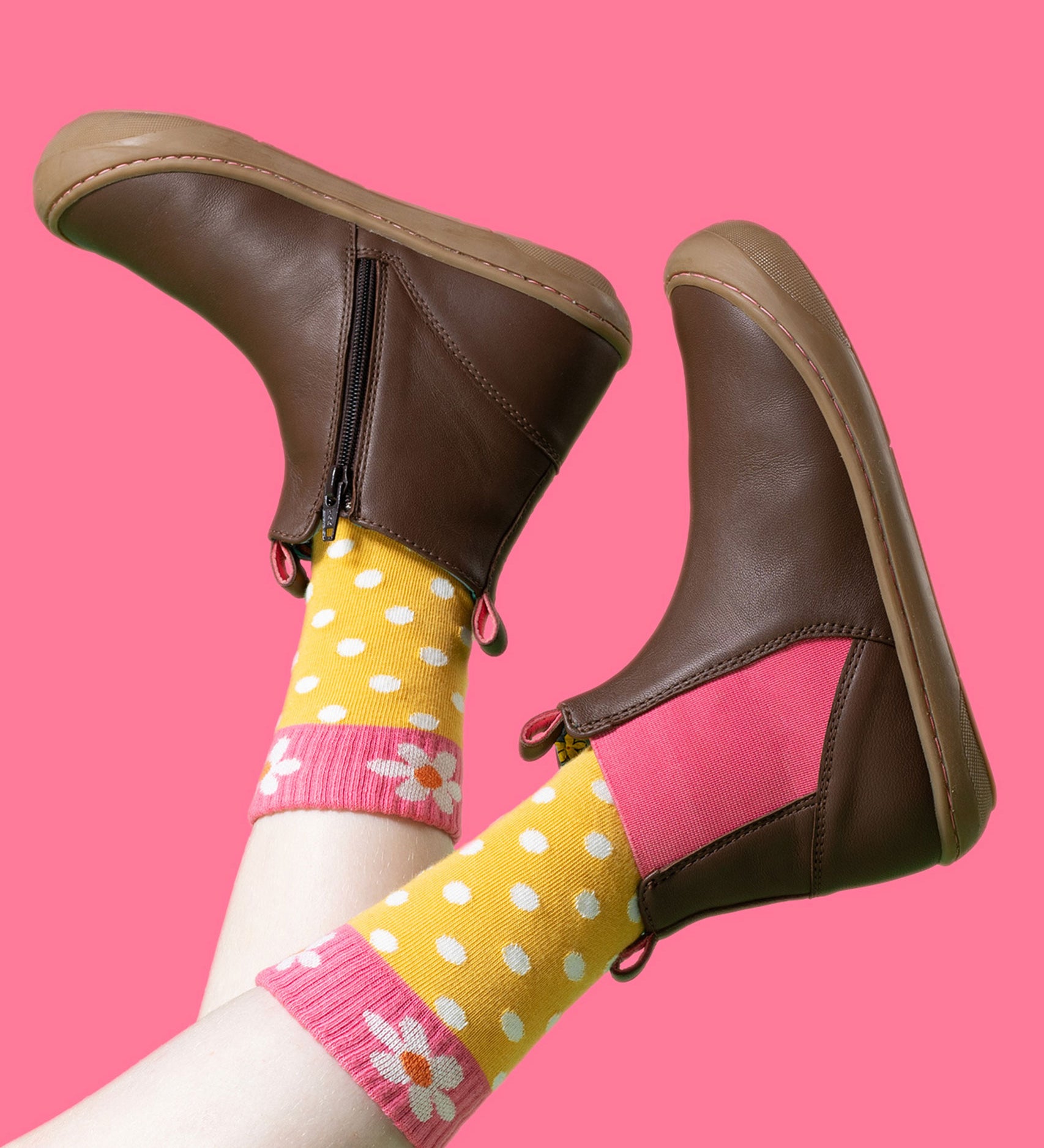 A child wearing the Frugi Ravine easy on children's leather boots in a brown, wild woods design with yellow dotted socks.