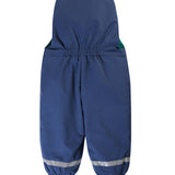 A child outside wearing the Frugi Children's Little Waterproof Dungarees - Navy Blue
