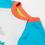 A close up of the Frugi Reid Raglan T-Shirt in Soft White featuring blue sleeves and a orange collar with popper fastenings.