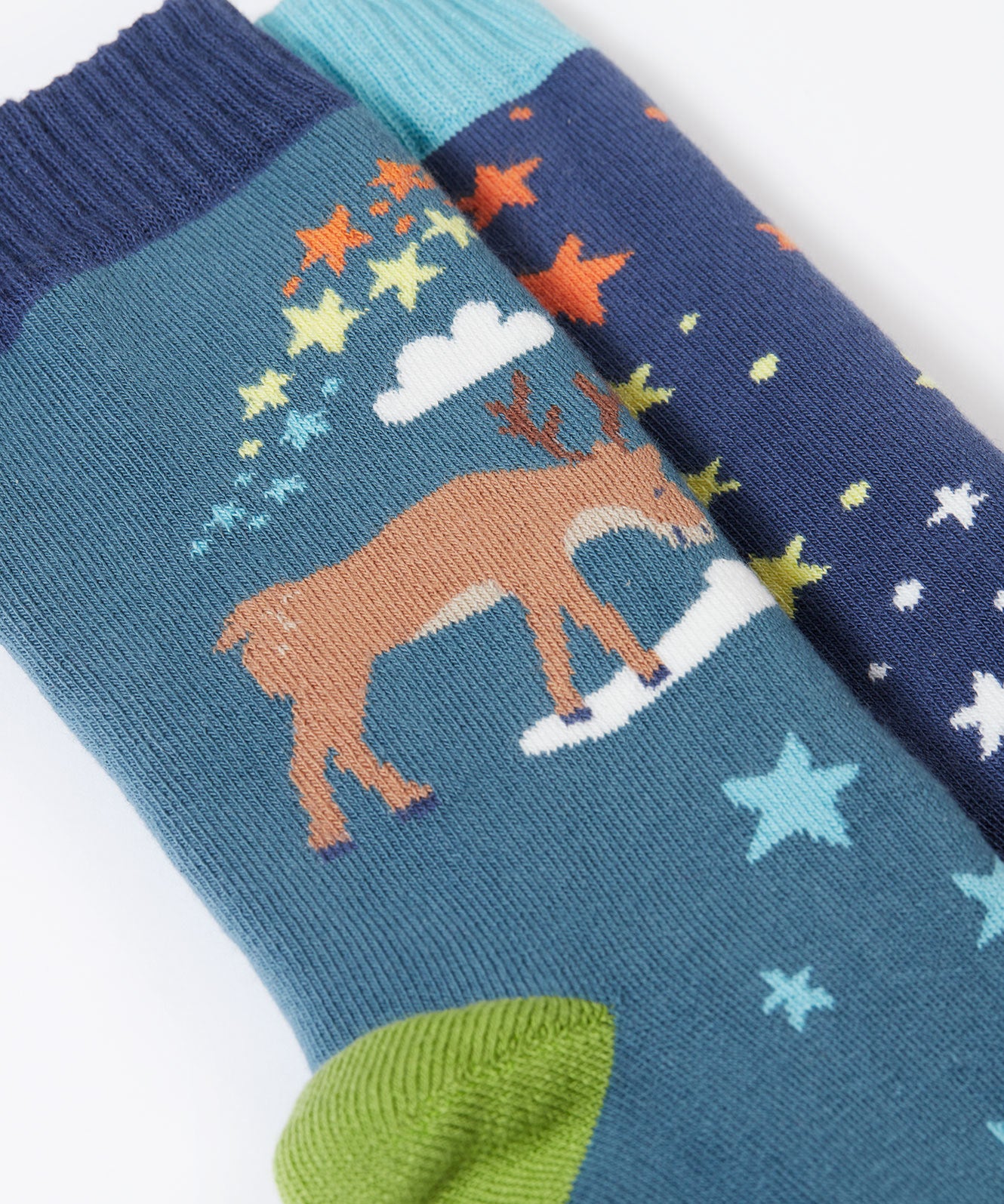 A close up of the reindeer on the Frugi Festive Reindeer Great Organic Cotton Grippy Socks for Kids 2 Pack. These socks have green coloured grippy stars on the soles. These socks are part of a wide range of organic cotton clothing for children available here at Babipur. 