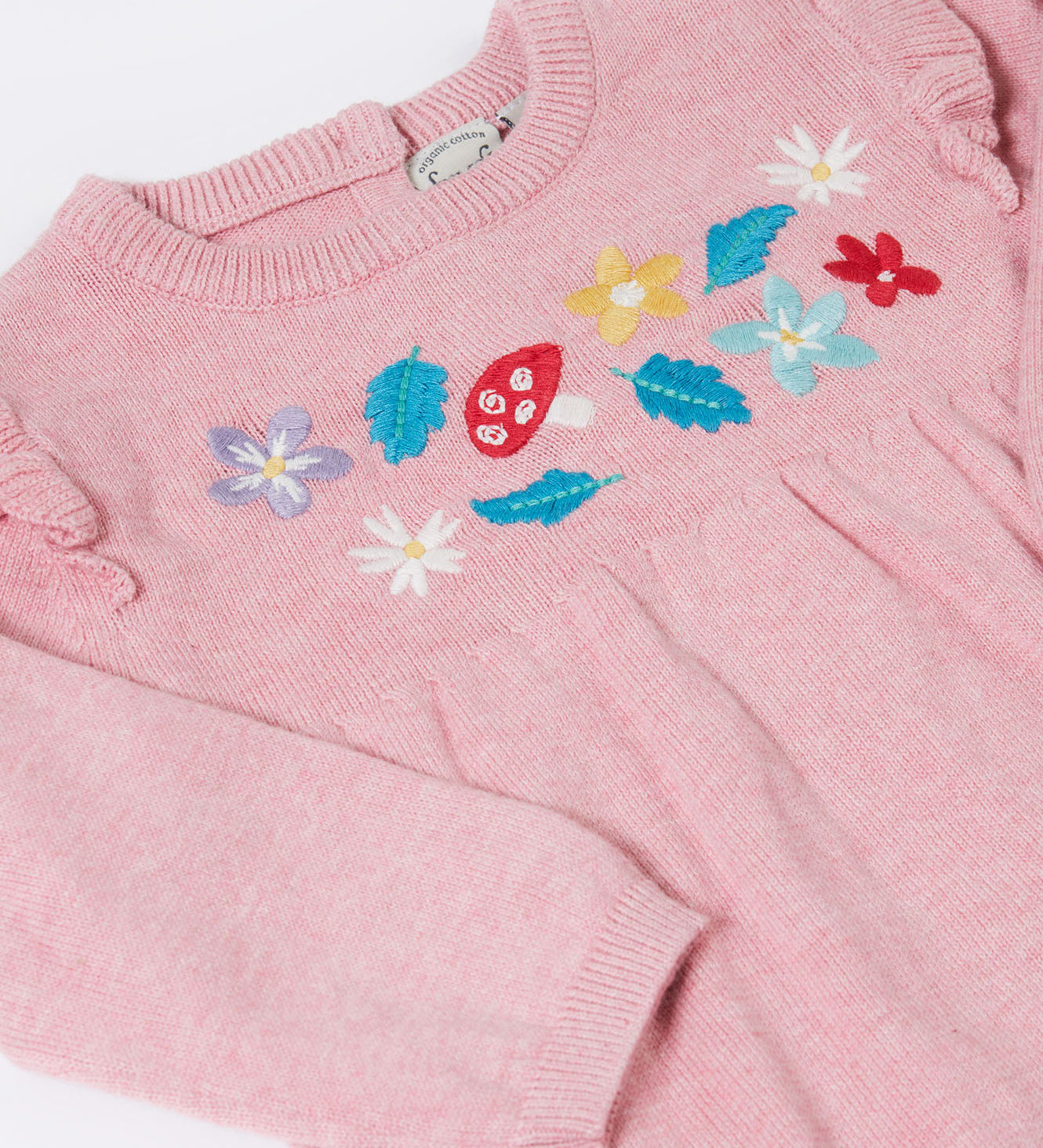 A close up of the Frugi kids remi knitted romper in pink marl /flowers showing the woodland inspired embroidery detail.
