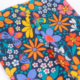 A close up of the waistband on the top of the A close up of the print on the Frugi Retro Floral Leona Organic Cotton Kids' Leggings. A navy coloured legging with a bright multicoloured retro style flower print all over. These leggings are part of a wide range of organic cotton clothing for children available here at Babipur. 