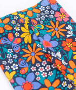 A close up of the waistband on the top of the A close up of the print on the Frugi Retro Floral Leona Organic Cotton Kids' Leggings. A navy coloured legging with a bright multicoloured retro style flower print all over. These leggings are part of a wide range of organic cotton clothing for children available here at Babipur. 